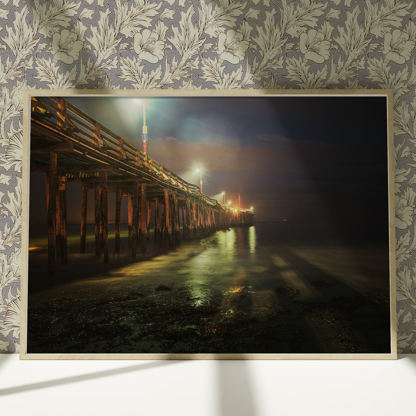 a picture of a pier at night on a wall