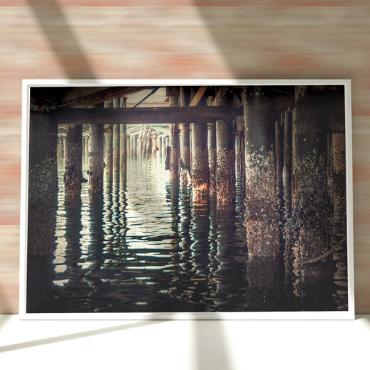 a picture hanging on a brick wall next to water