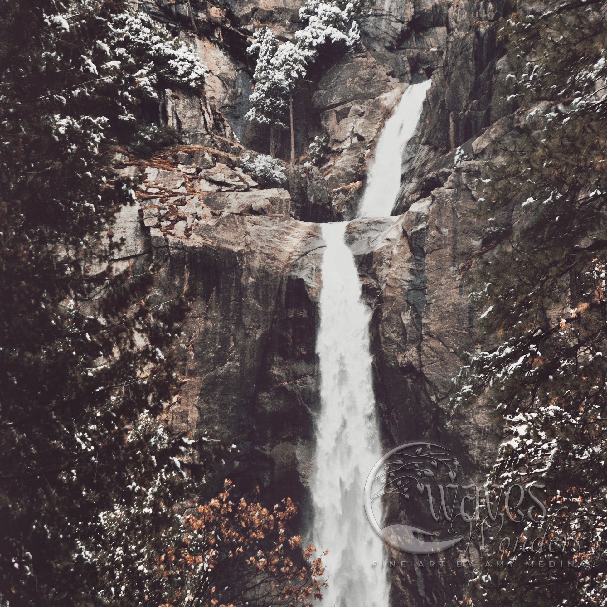 a waterfall with snow on the ground and trees around it