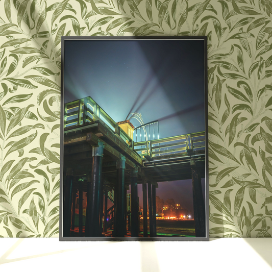 a framed photograph of a pier at night