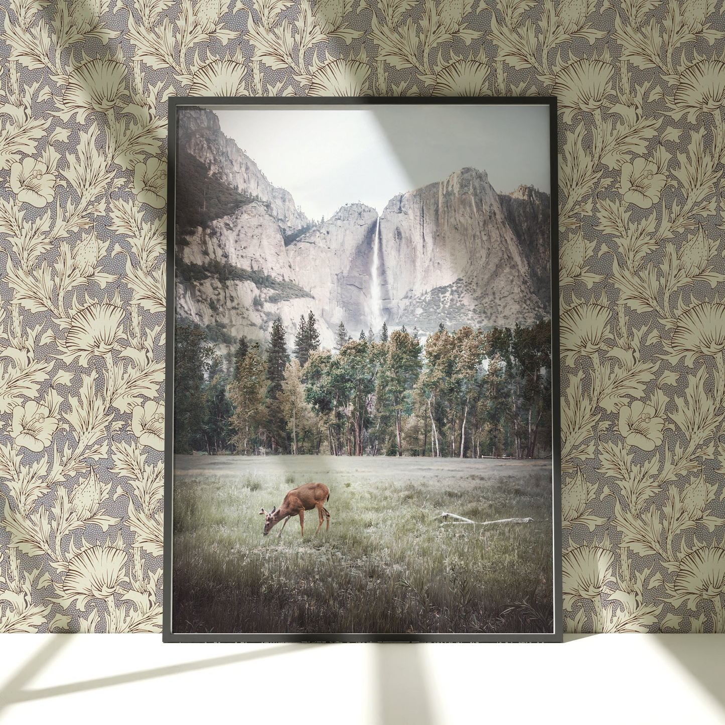 a picture of a deer in a field with mountains in the background