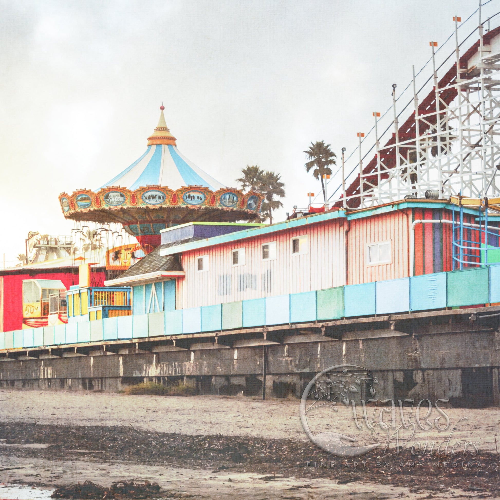 a carnival ride is on the beach next to a pier