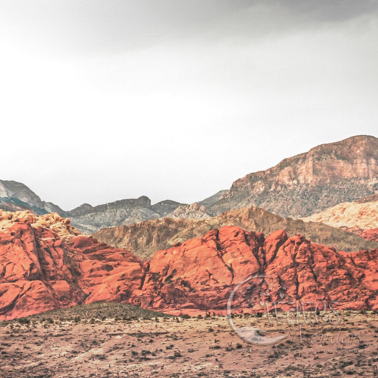 a mountain range with red rocks in the foreground