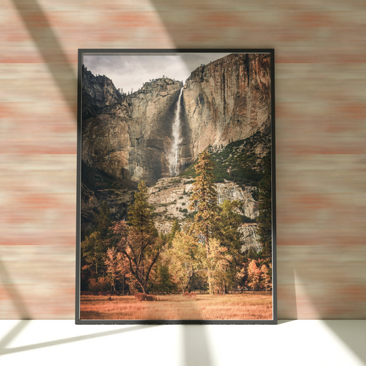 a picture frame hanging on a wall with a picture of a waterfall