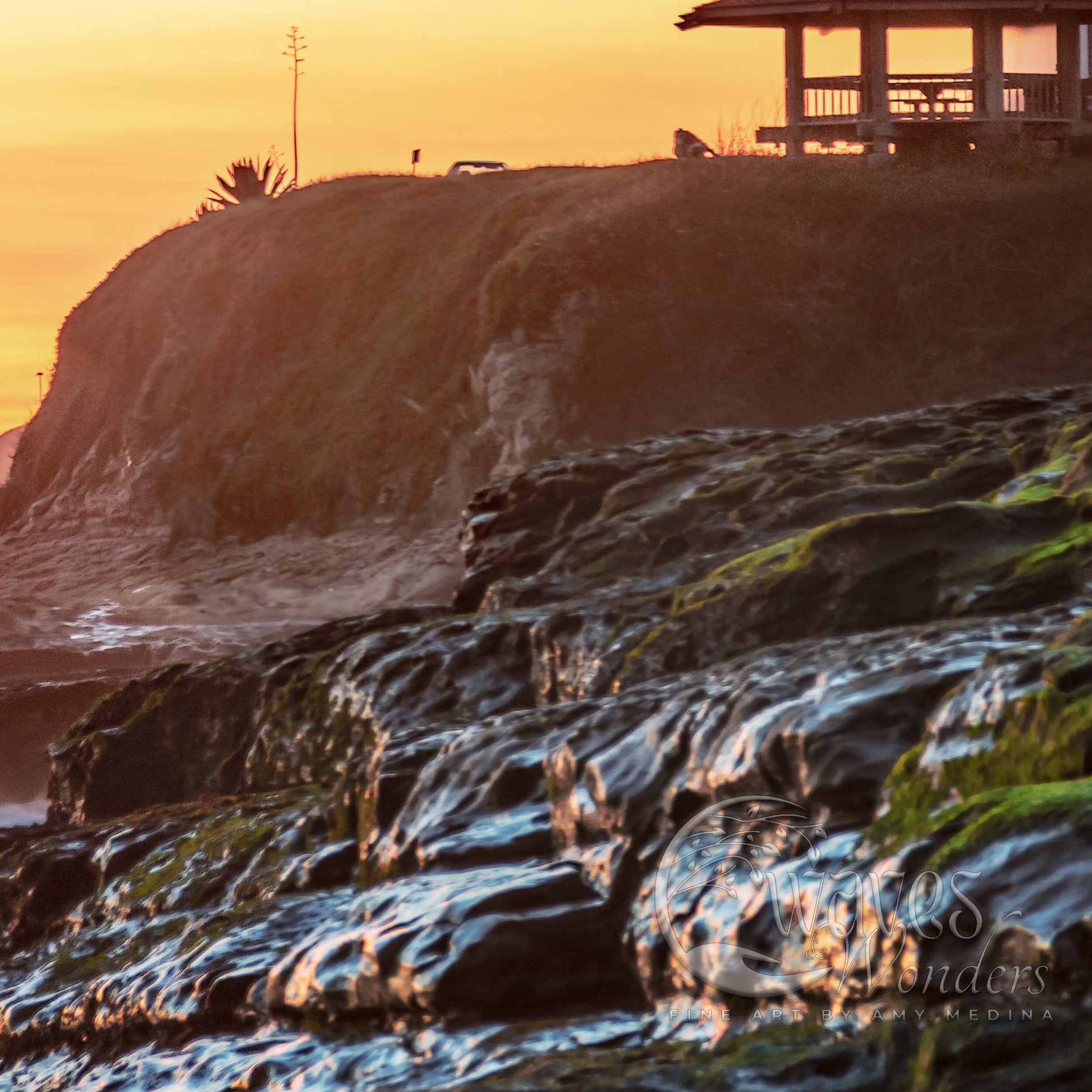 a couple of people standing on top of a rocky beach