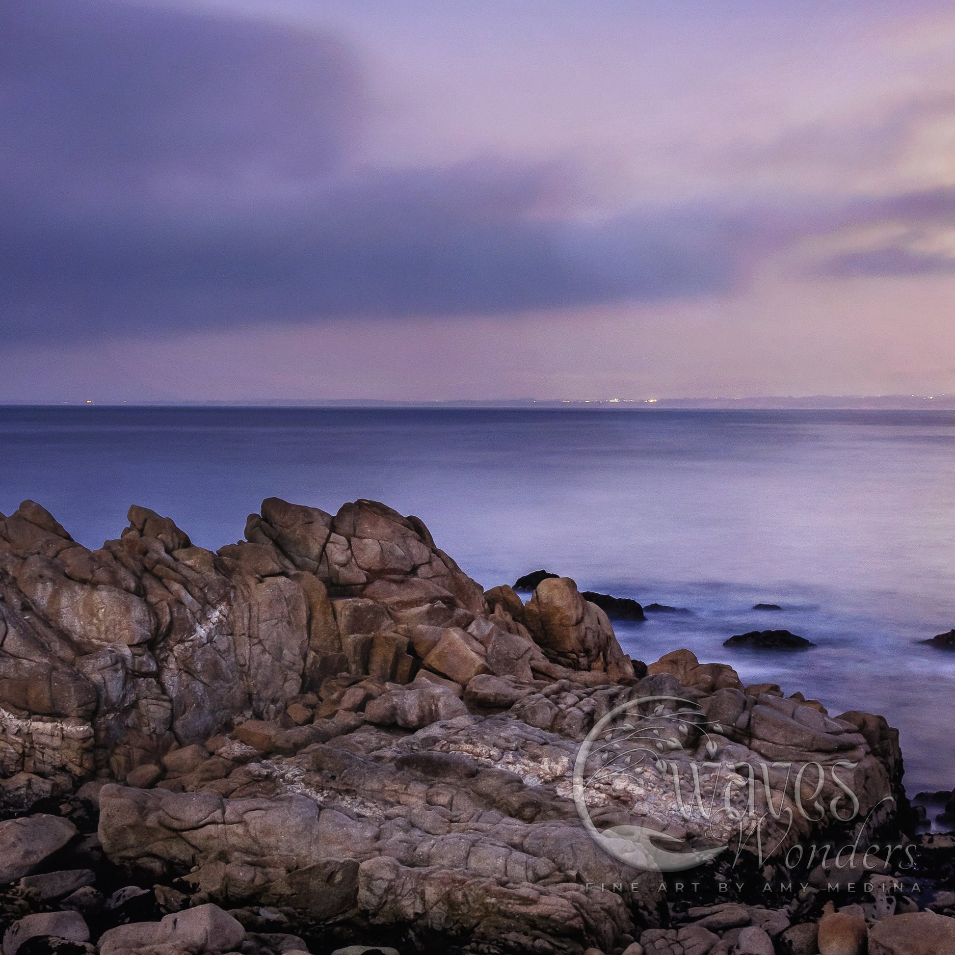 a rocky shore with a lighthouse in the distance