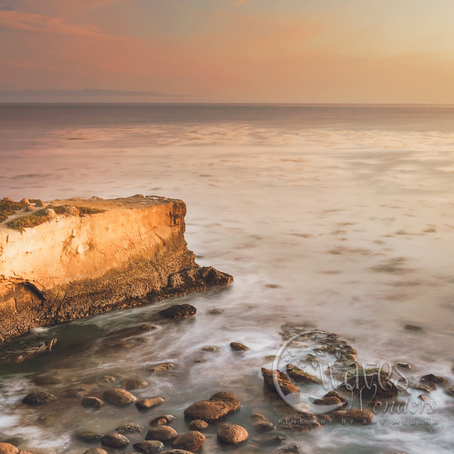 a large rock sitting on top of a beach next to the ocean