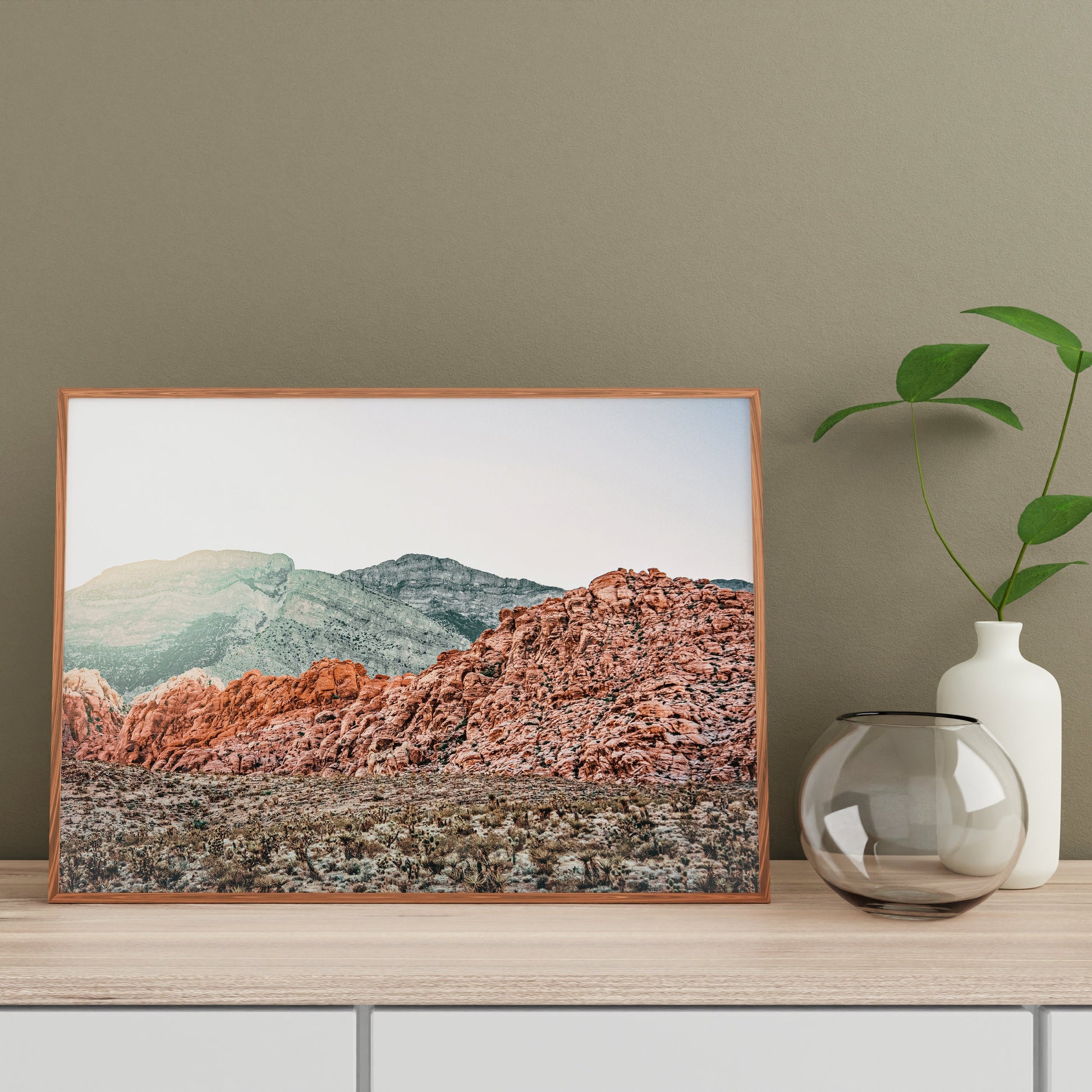 a vase with a plant in it next to a picture