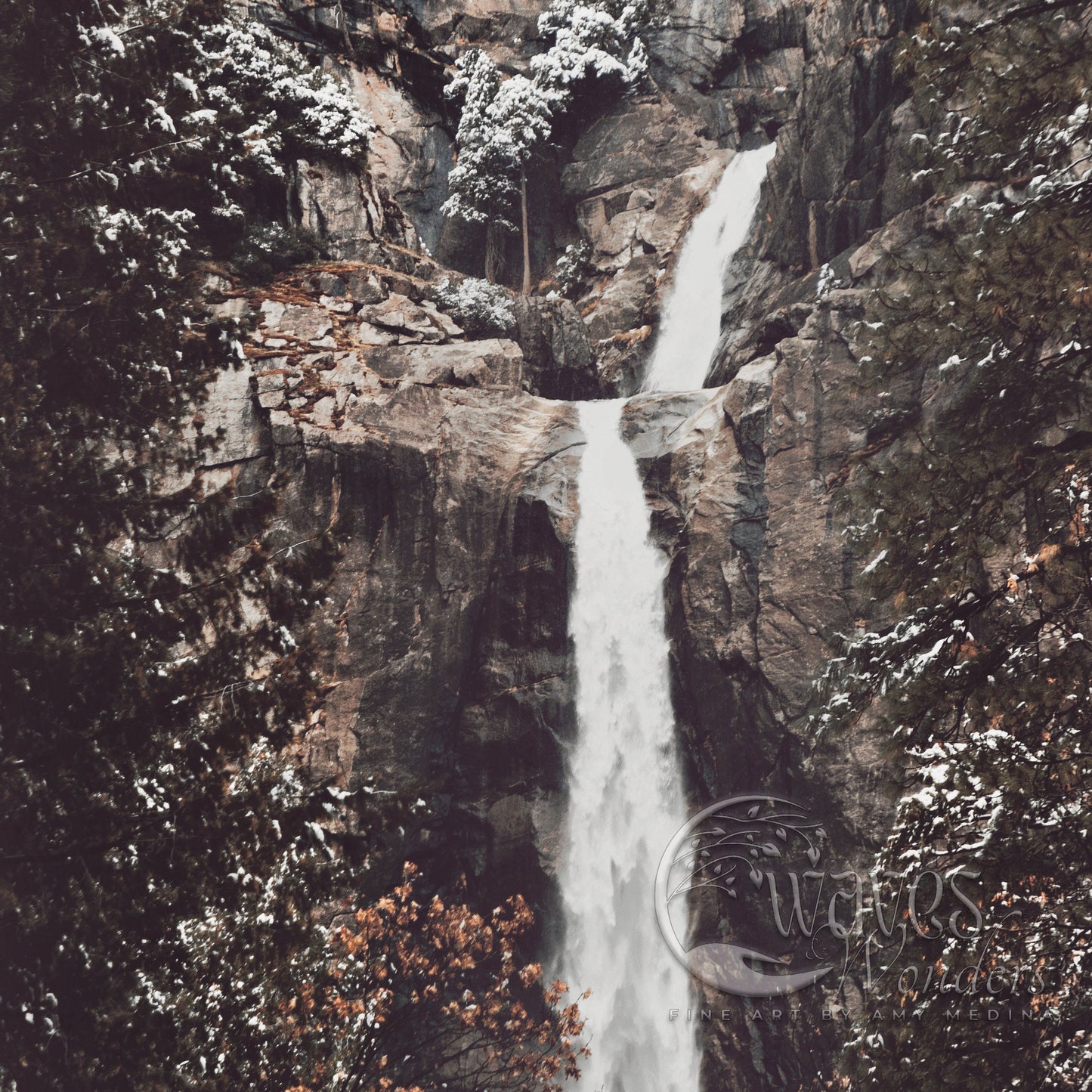 a waterfall with snow on the ground and trees around it