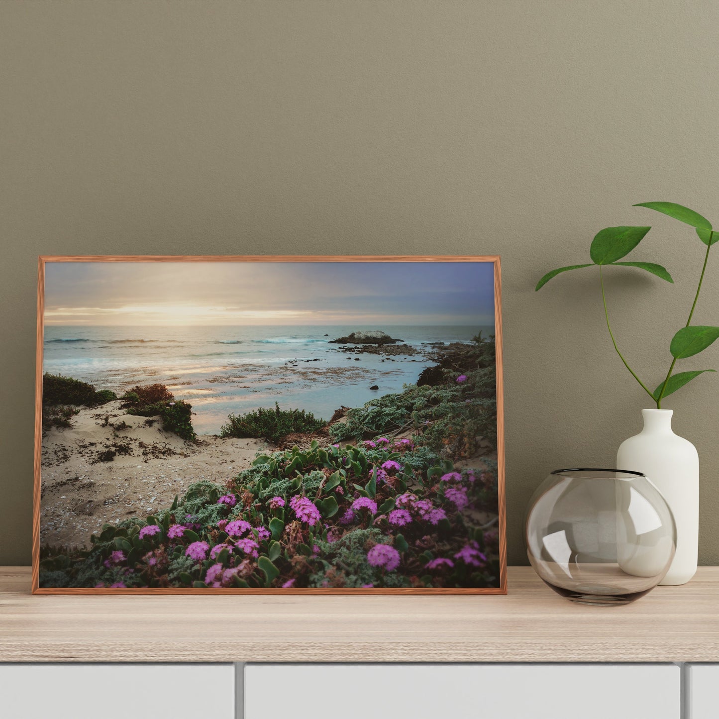 a picture of a beach with flowers and a vase