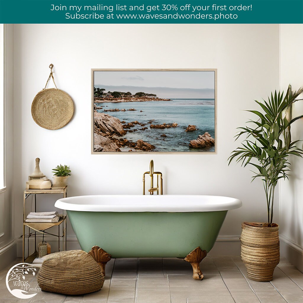 a bathroom with a green bathtub and a picture on the wall