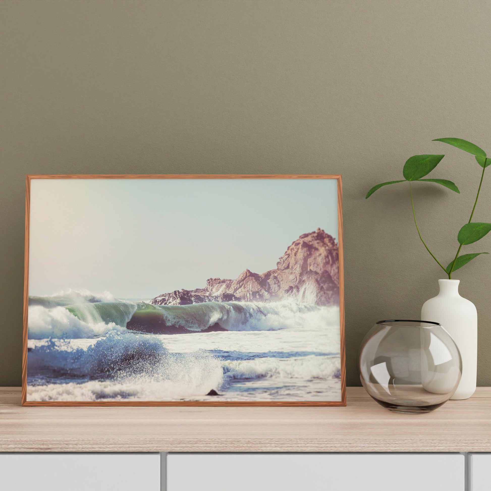 a vase with a plant and a picture on a shelf