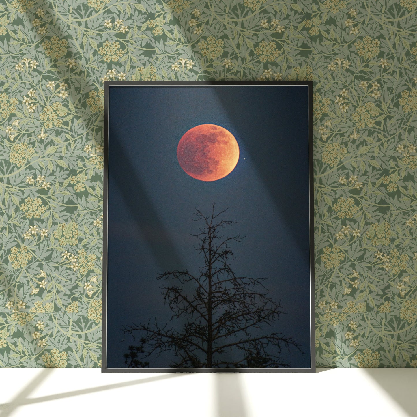 a picture of a red moon in the sky above a tree