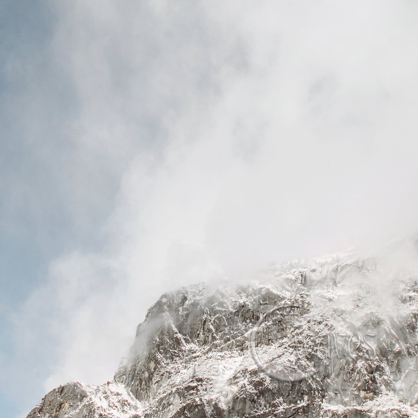 a mountain covered in snow under a cloudy sky