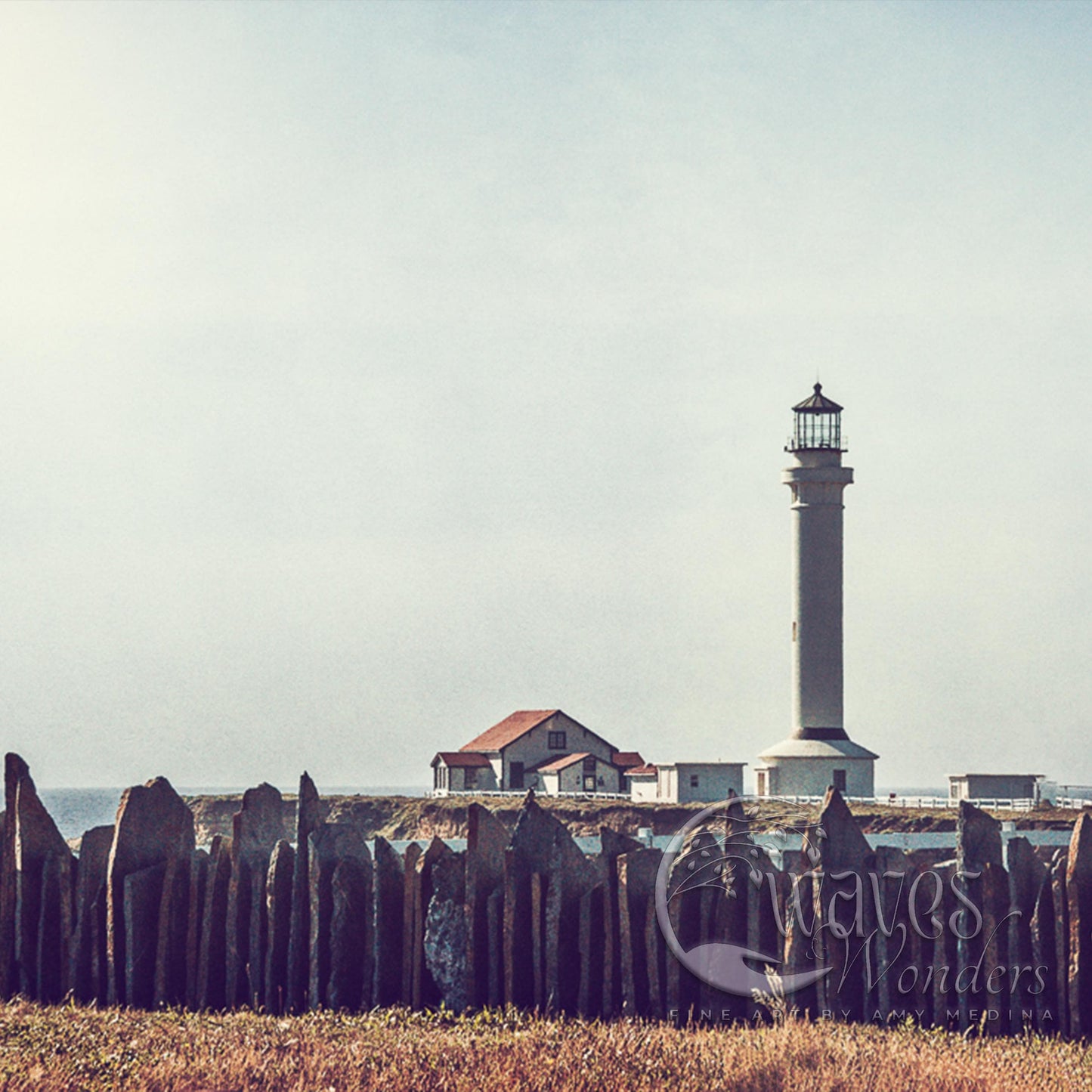 a light house sitting on top of a grass covered field