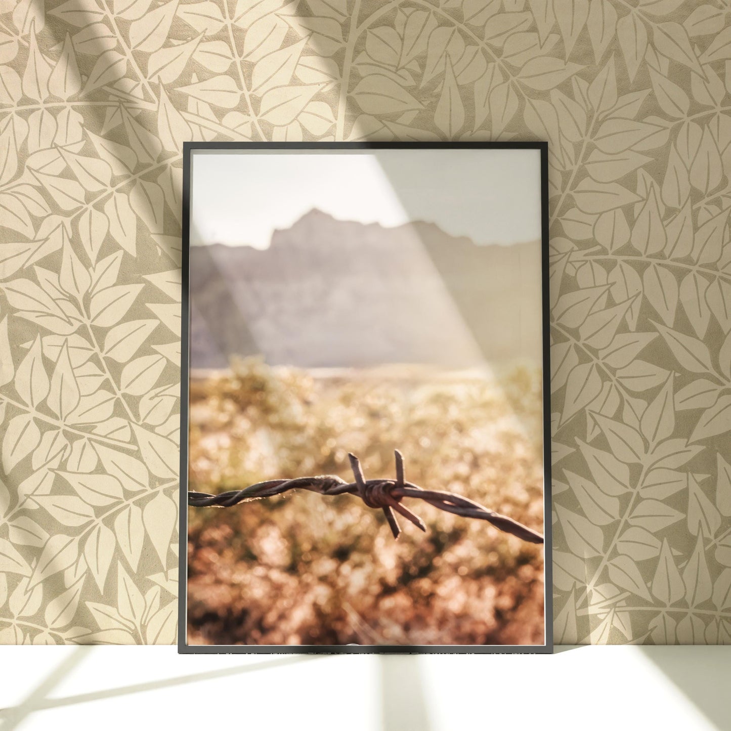 a picture of a barbed wire with mountains in the background