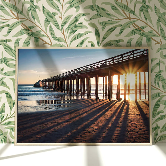 a picture of a pier on the beach at sunset