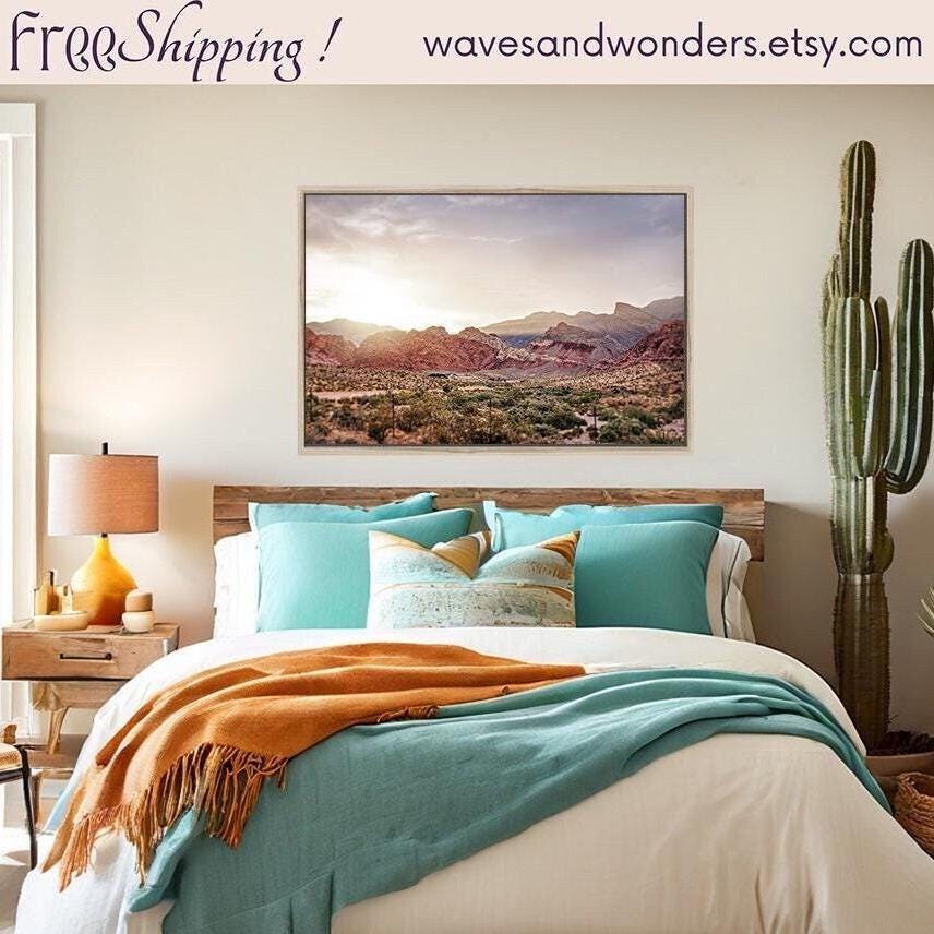 a bed in a bedroom with a painting on the wall