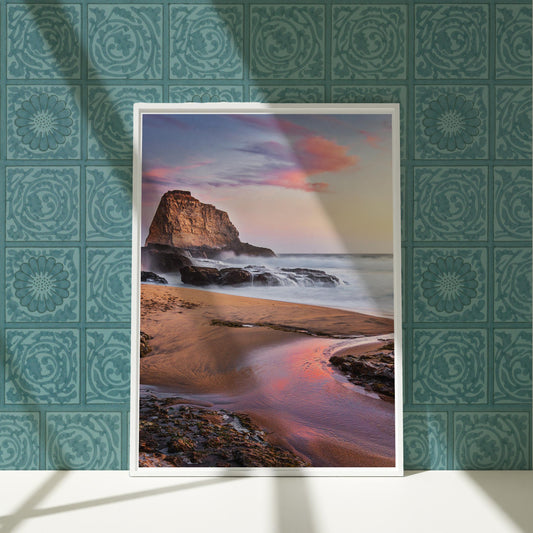 a picture of a beach with a rock in the background